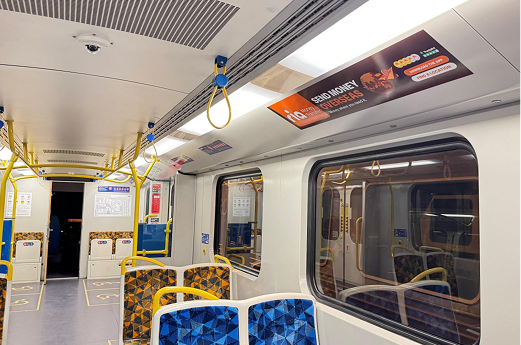 RIA Money Transfer ad panel above train seating